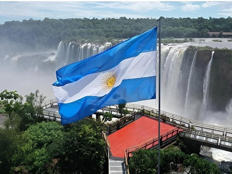 An Argentine flag flying at a viewpoint above the falls