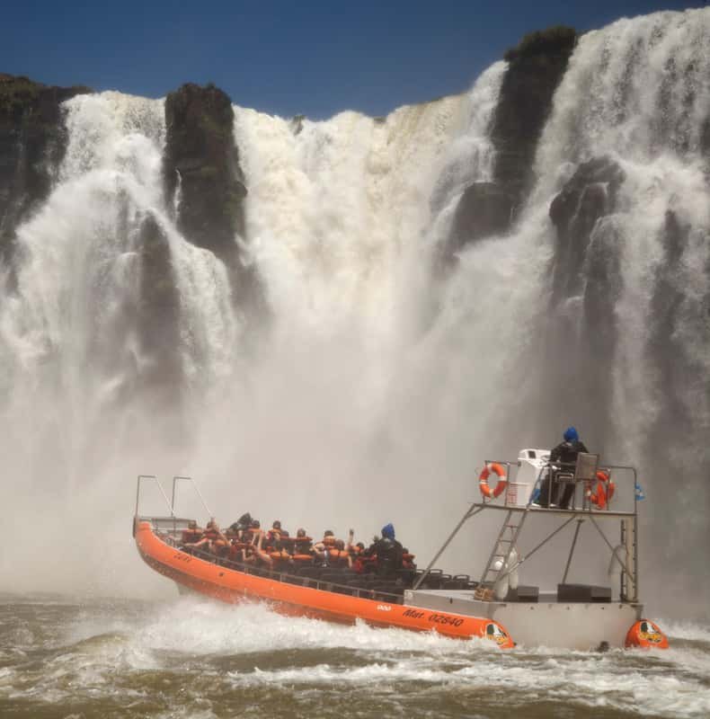 A boat driving in under the falls