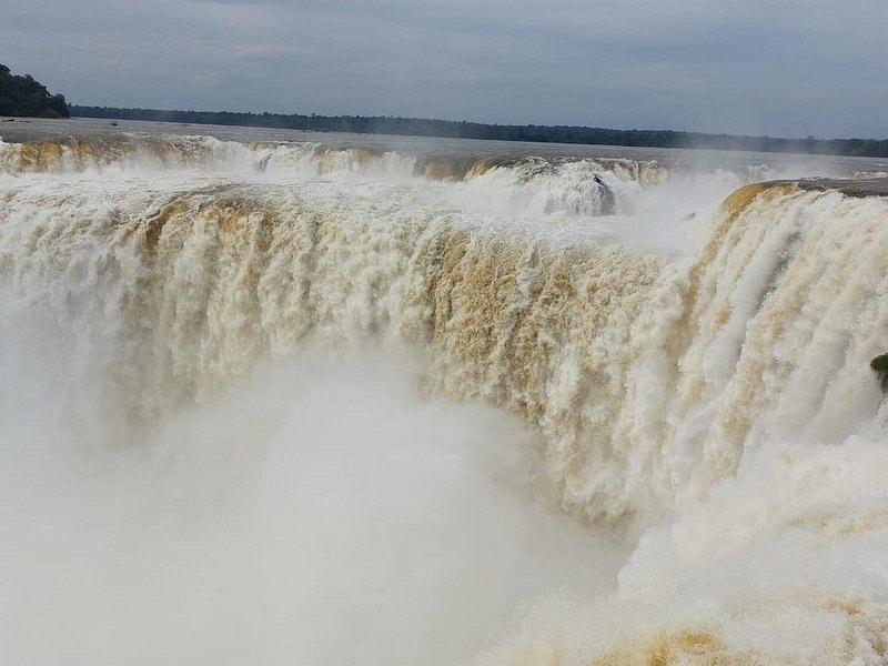 The Devil's Throat carrying a heavy, silt-brown flow