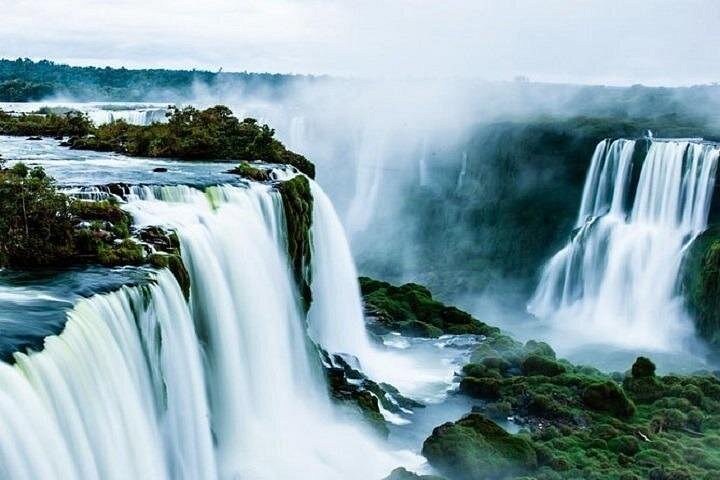 Clear green water going over a step of the falls