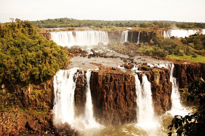 Water dropping over the red basalt shelves that carry the falls