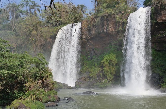 Two falls dropping side by side into the forest